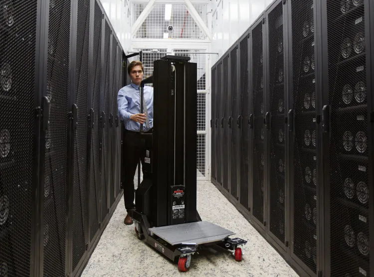 Empleado realiza traslado de servidores en un centro de datos